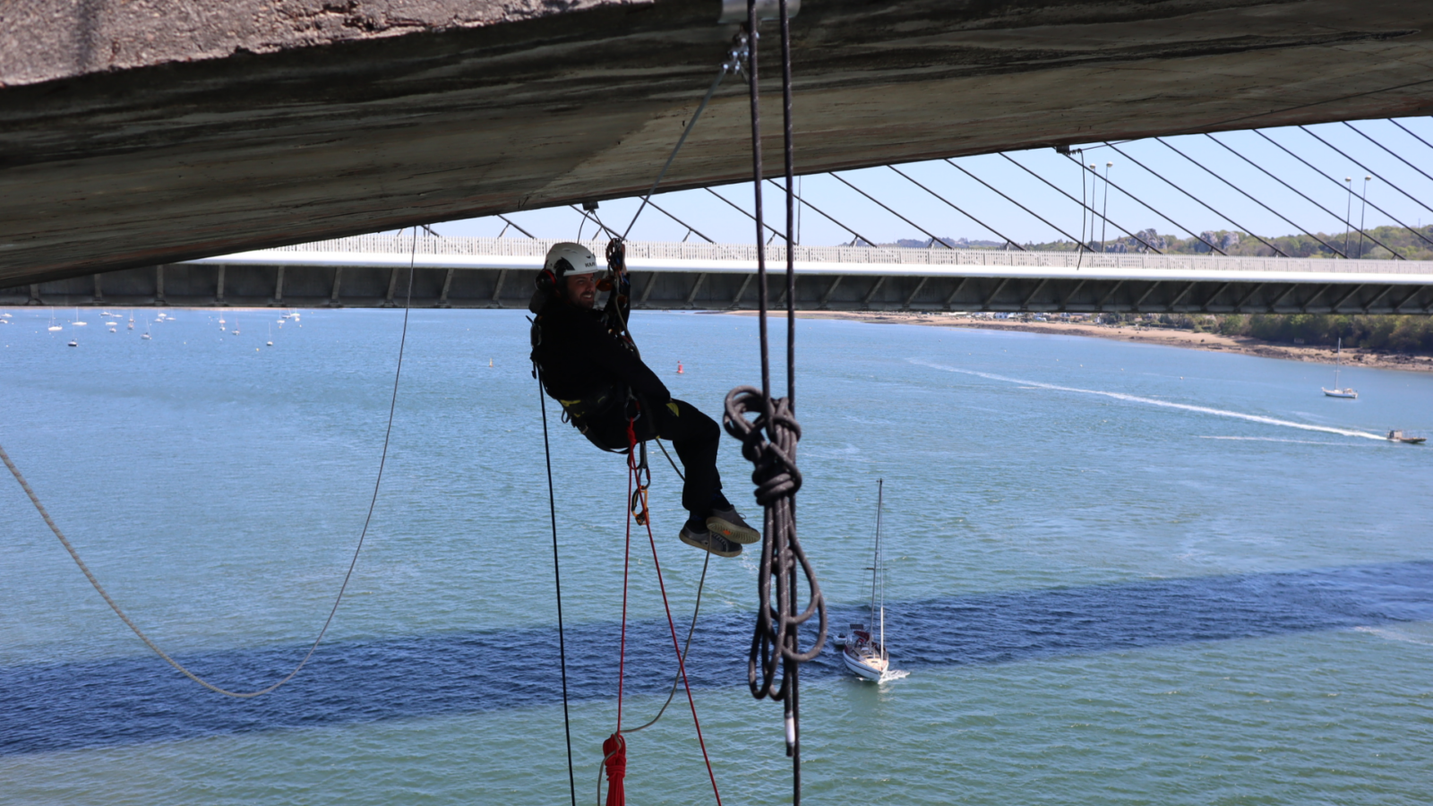 cordiste accroché sous un pont